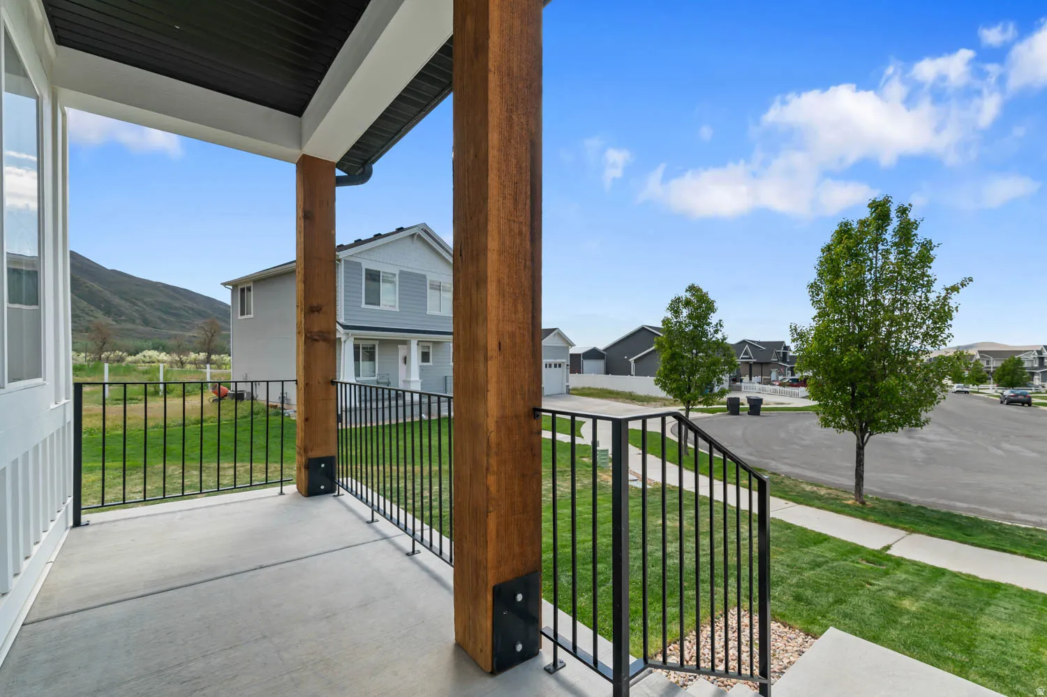 Covered porch with concrete flooring and dark metal railing
