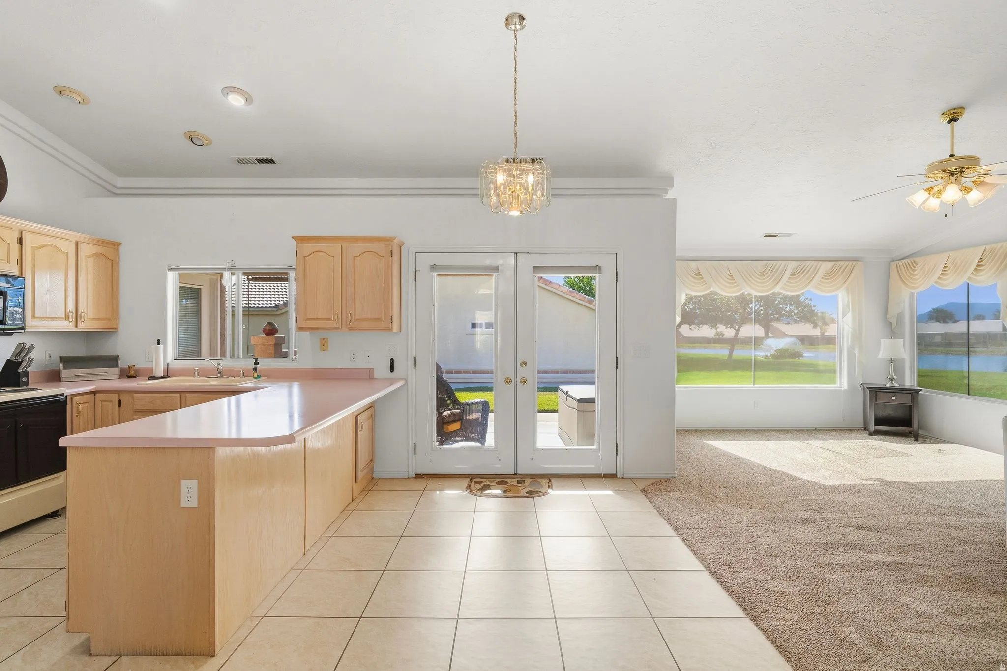 Open-concept living area with a kitchen island, recessed lighting, and a chandelier