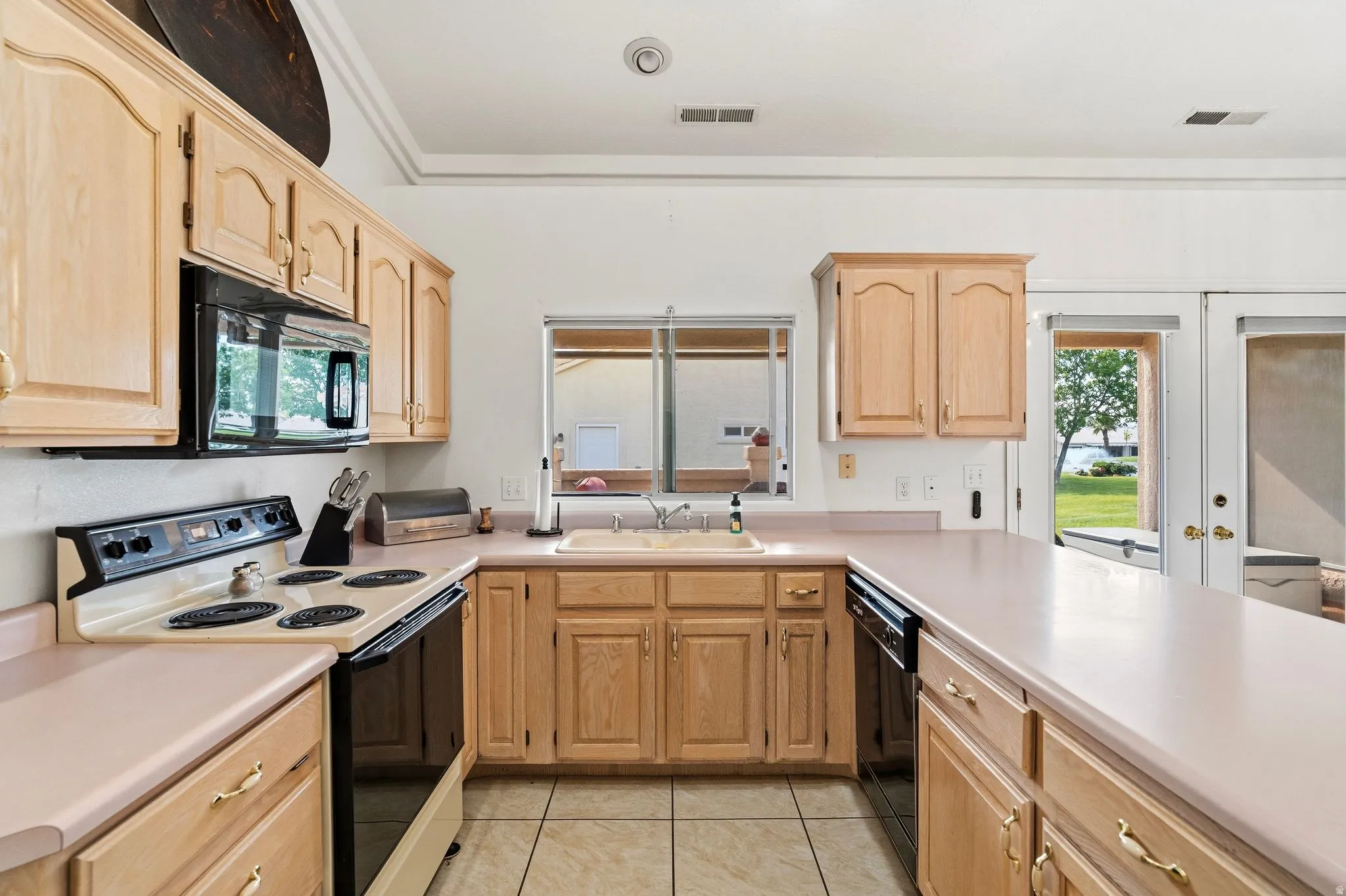 Kitchen featuring light wood cabinetry and light-toned countertops