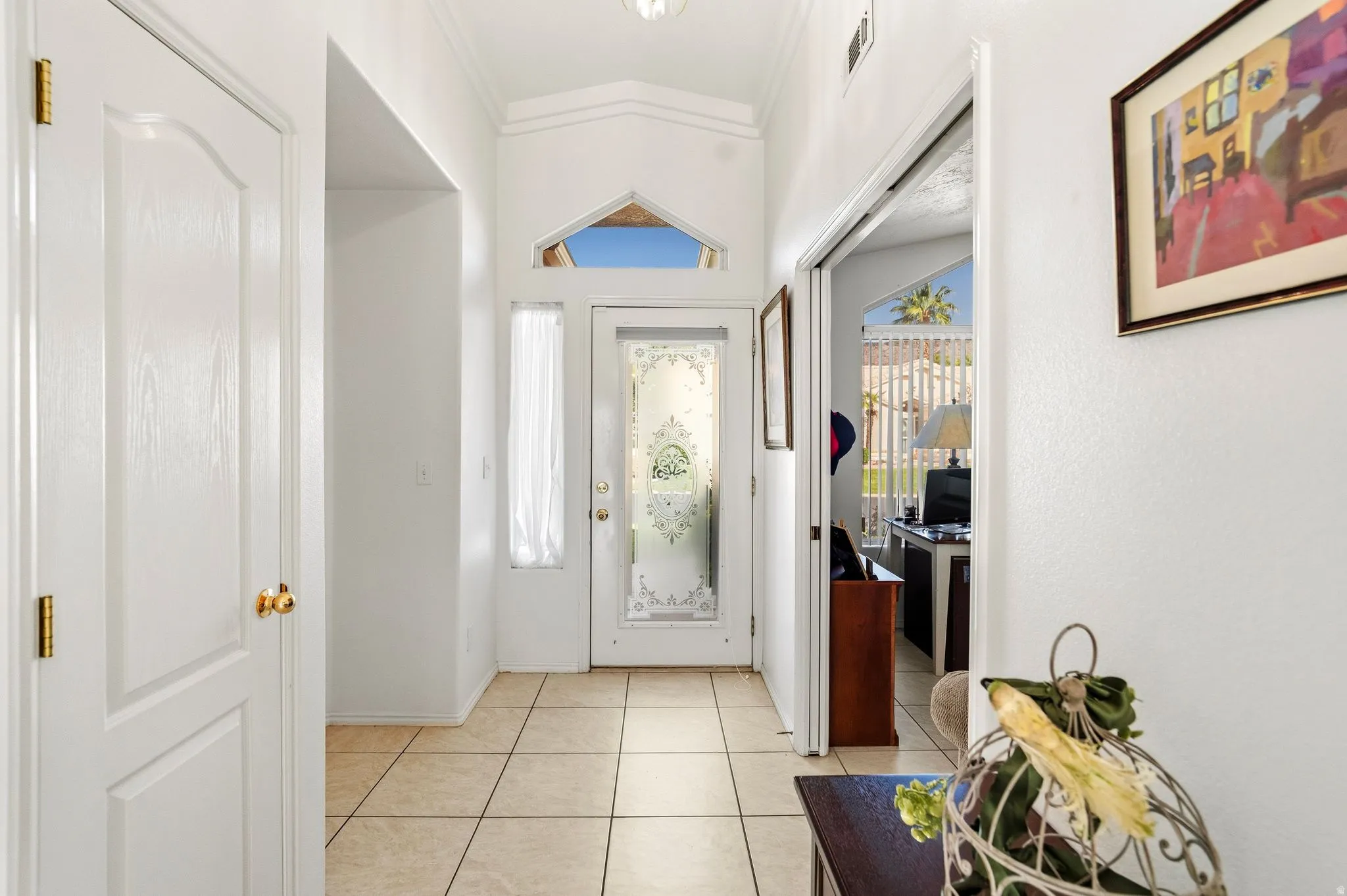 Bright entryway with tiled flooring and a decorative glass front door