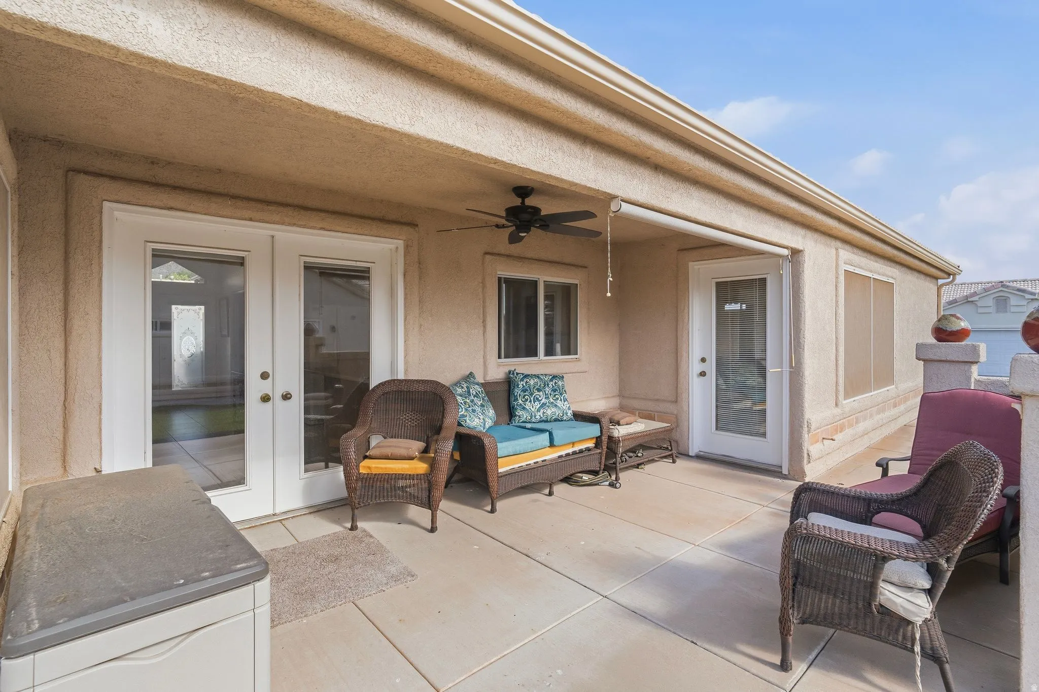 Covered patio featuring a concrete slab, exterior ceiling fan, recessed lighting, and two sets of exterior doors