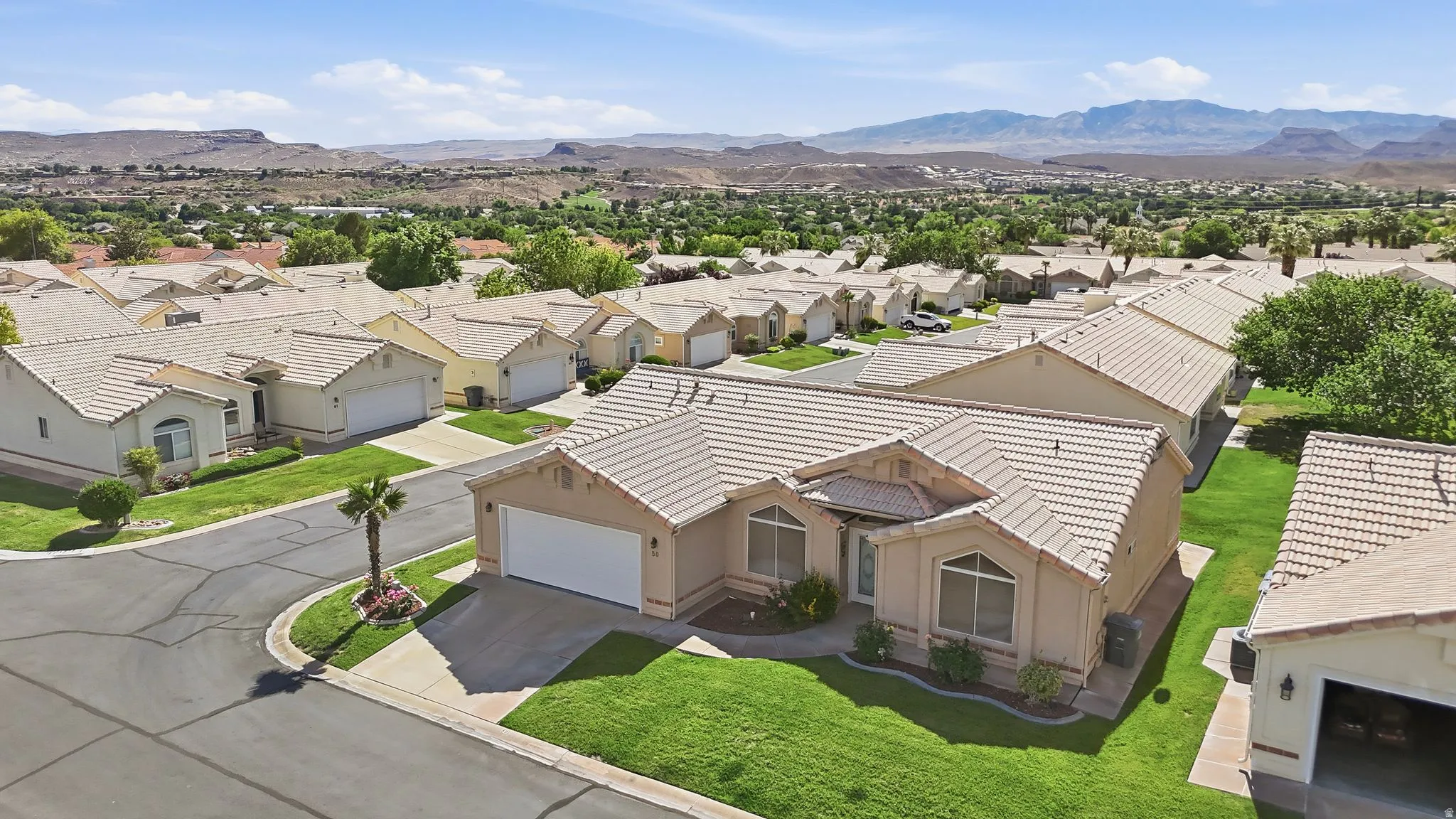 Single-story residence featuring a two-car garage, stucco exterior, and tile roofing