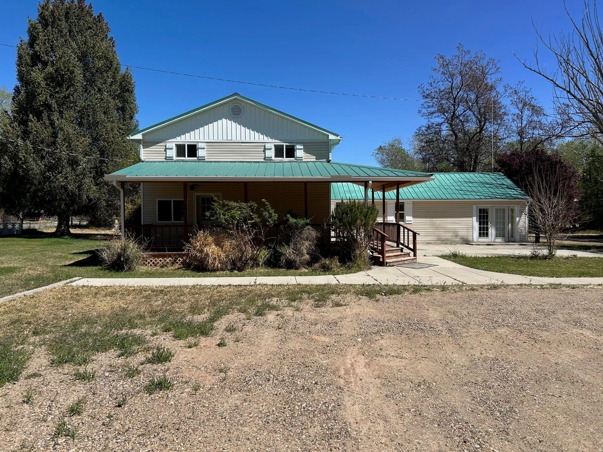 Property featuring a two-story residence with a covered front porch and a detached structure