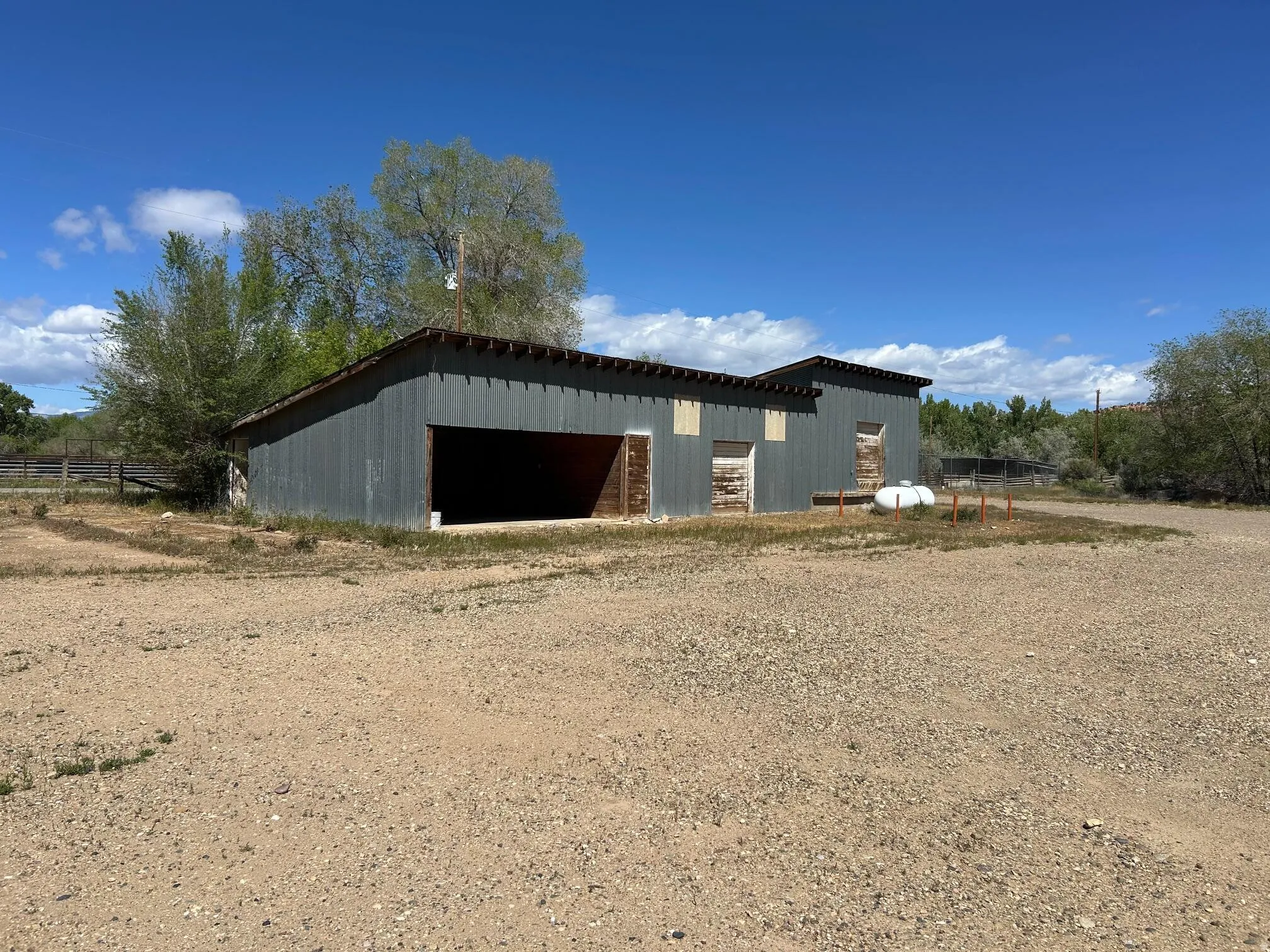Corrugated metal outbuilding with multiple entry points and an open bay