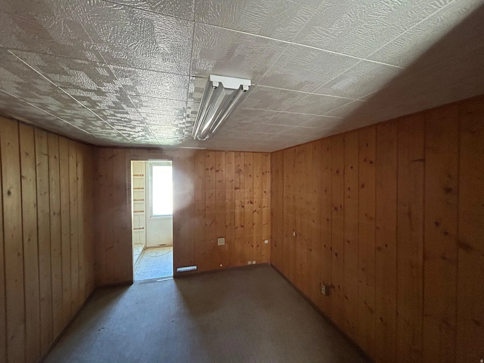 Paneling-clad walls feature a window opening