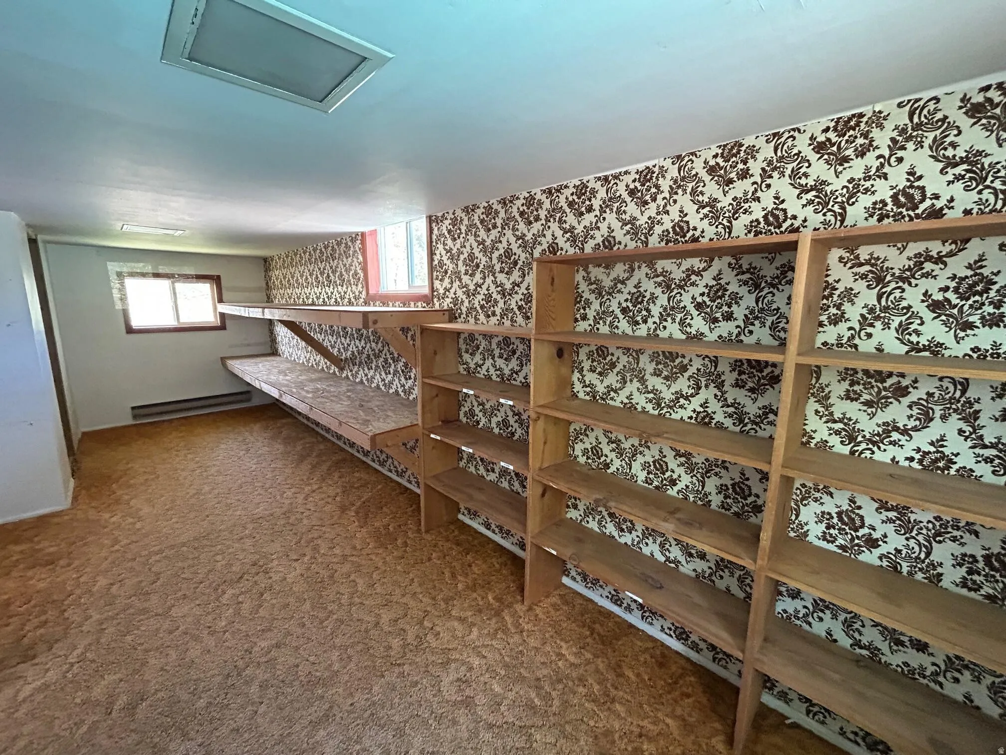 Room featuring built-in shelving, a recessed lighting fixture, and patterned wallpaper