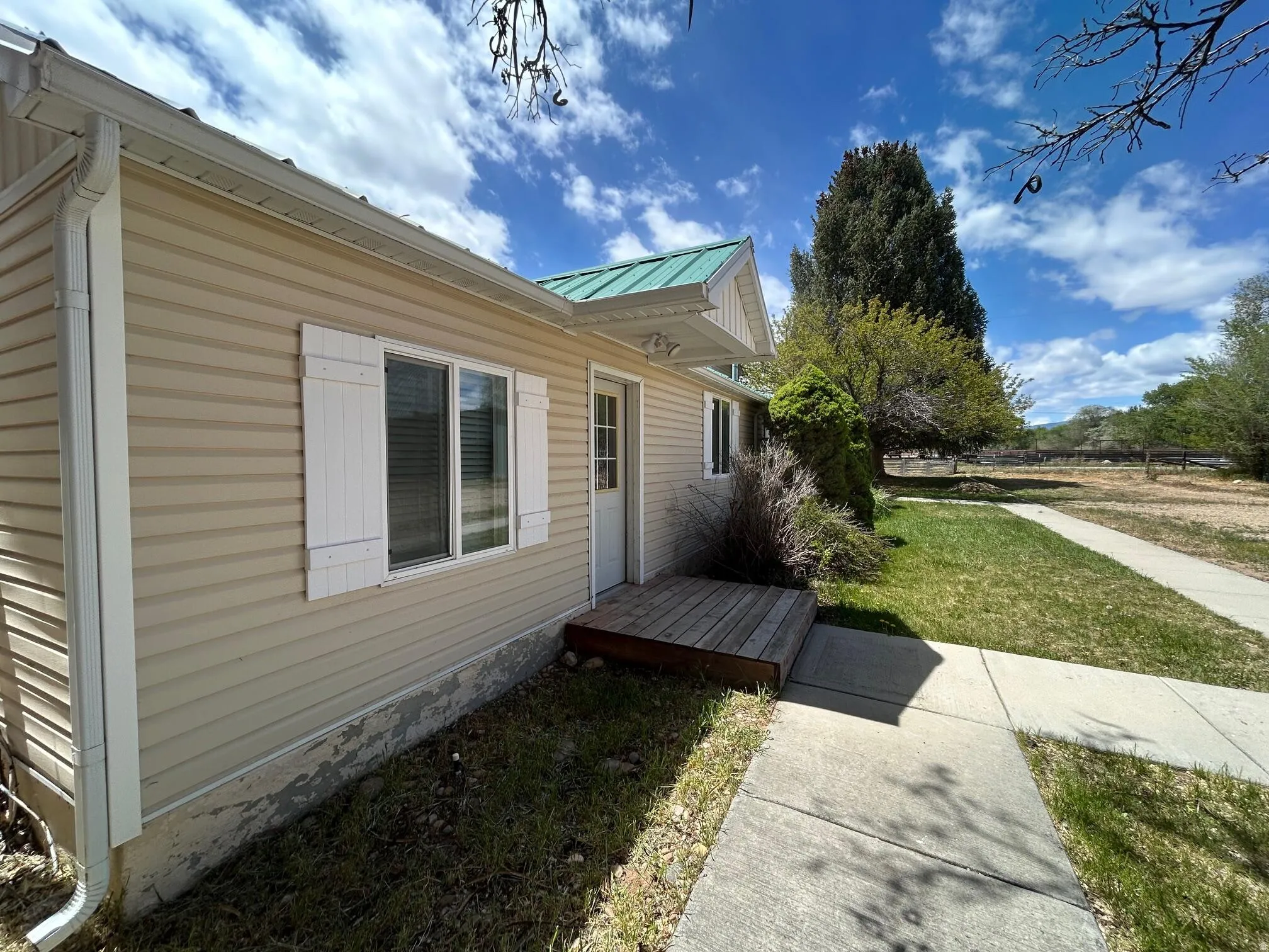 Light-colored siding exterior with white window shutters