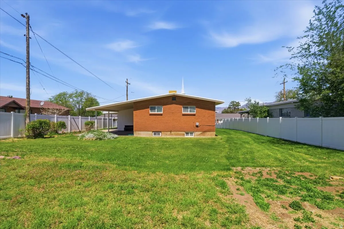 Expansive lawn area bordered by white vinyl fencing