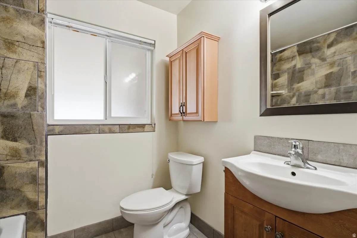 Bathroom featuring a wood-finish vanity with an integrated sink and chrome faucet