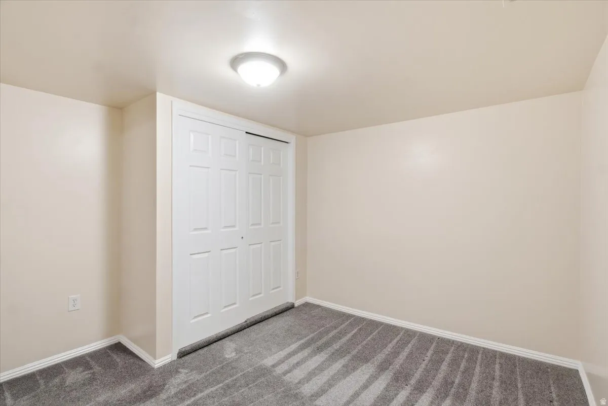 Neutral-toned interior room featuring light beige walls and a patterned gray carpet