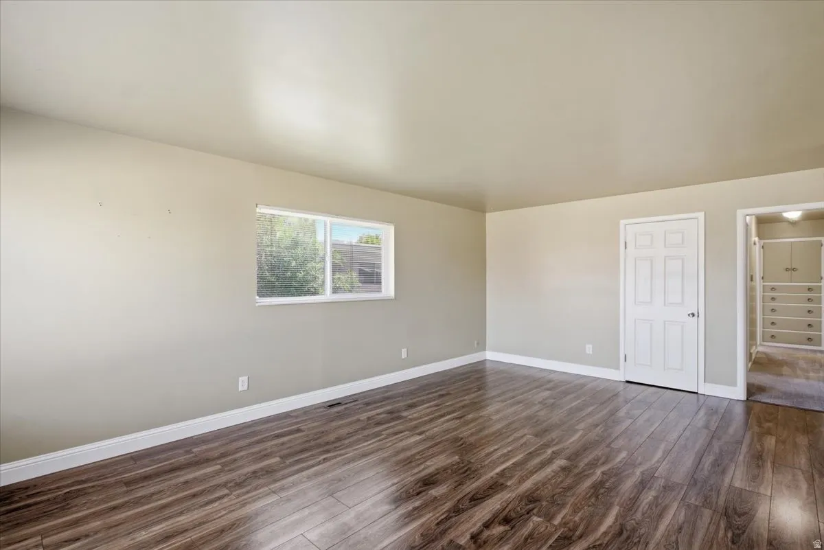 Spacious interior featuring wood-finish flooring, light neutral wall paint, and white trim