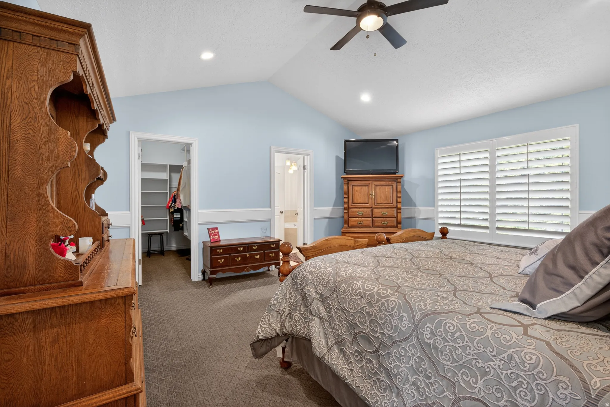 Vaulted ceiling bedroom with light blue walls and wainscoting