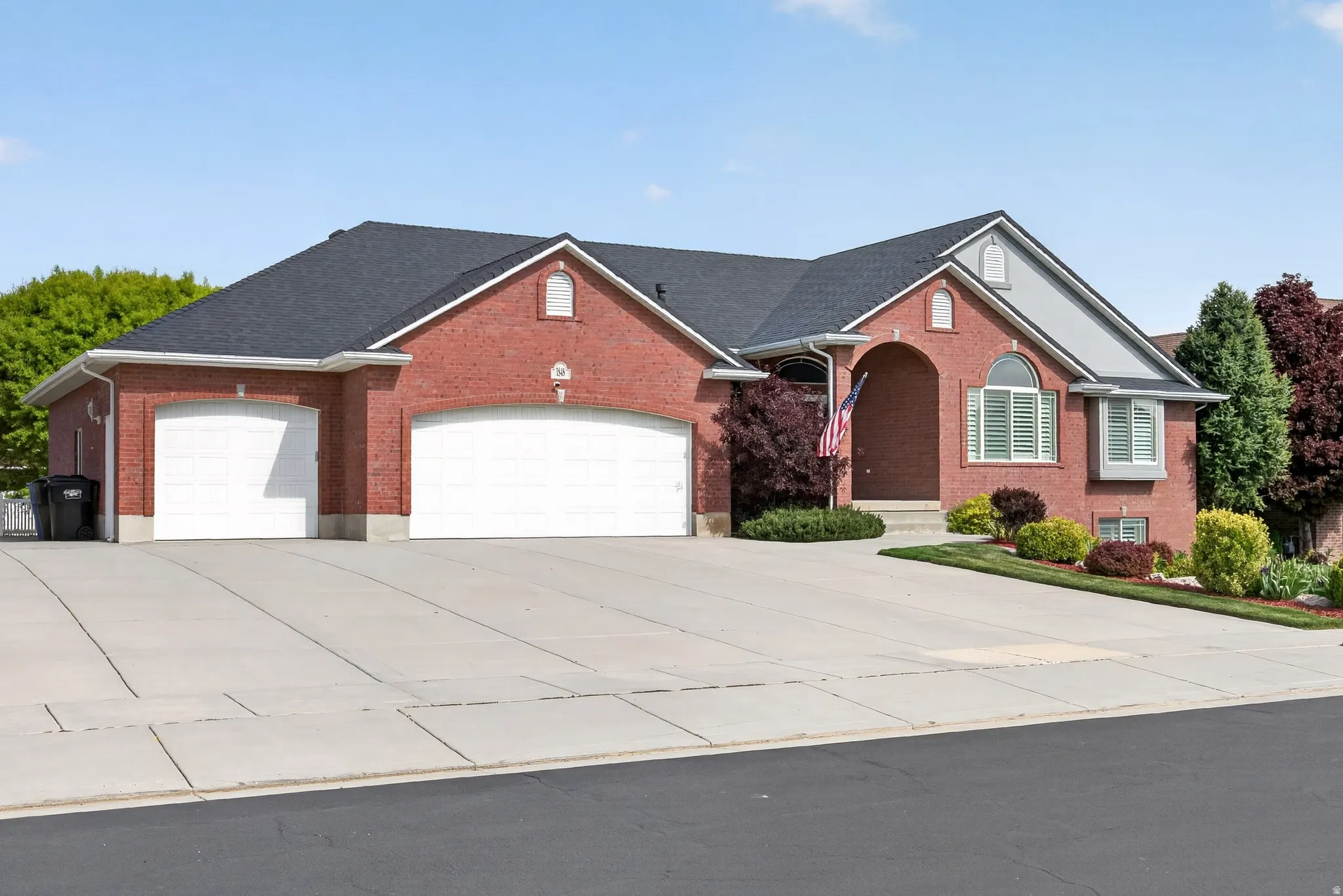 Red brick exterior with dark shingle roofing