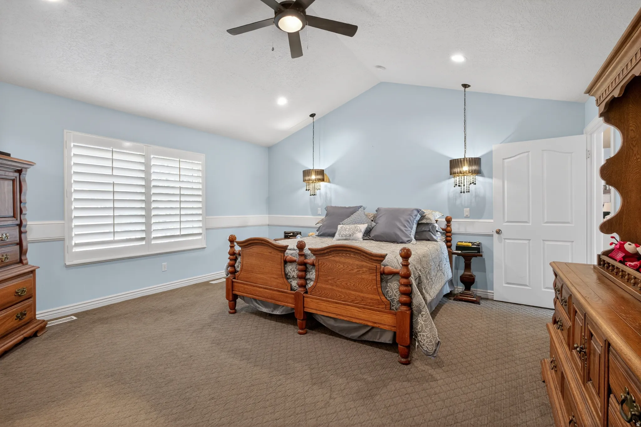 Spacious room featuring vaulted ceilings, recessed lighting, and a ceiling fan