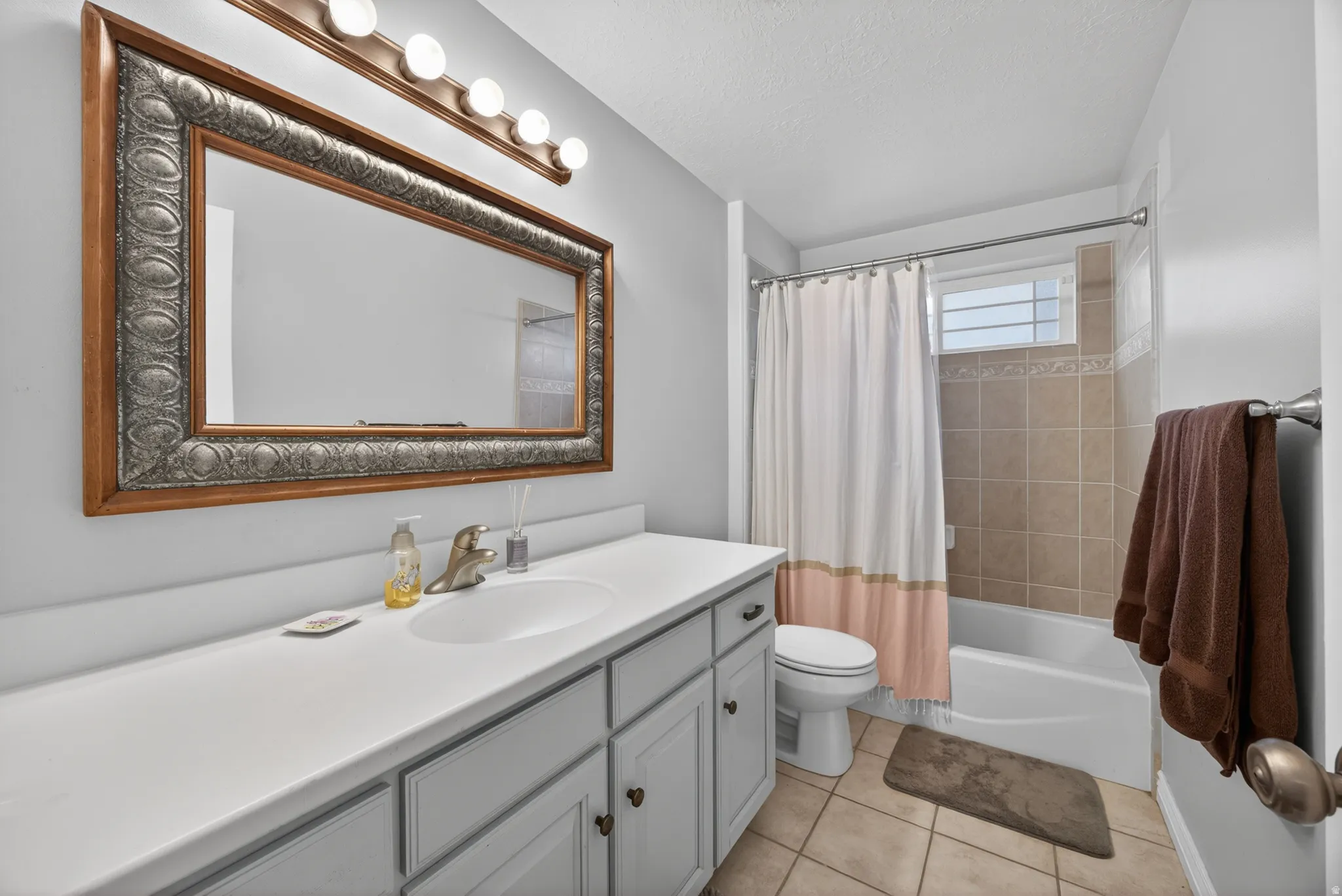 Vanity area featuring a large framed mirror, a single basin sink, and ample counter space