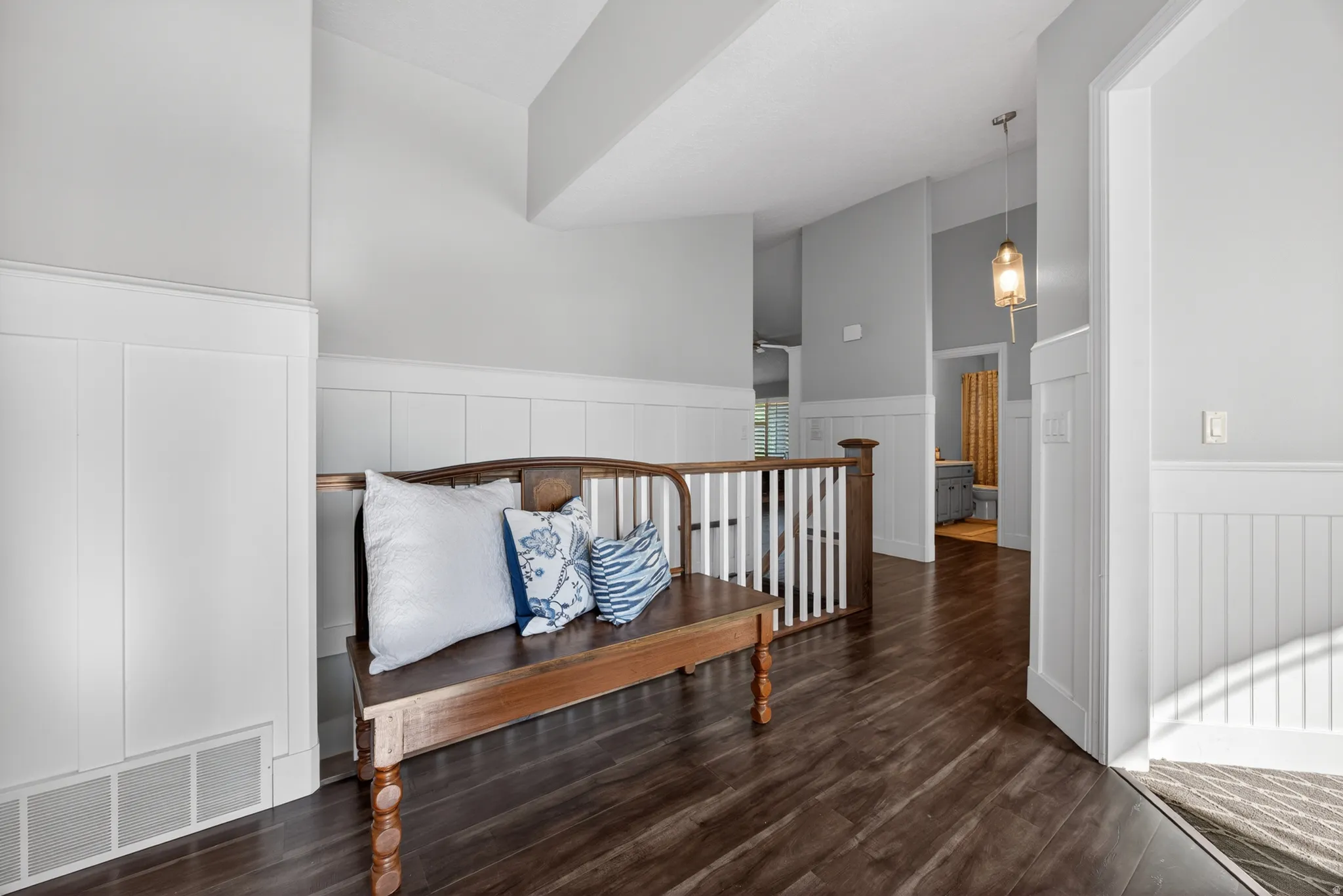 Inviting entryway featuring dark wood-finish flooring and white wainscoting
