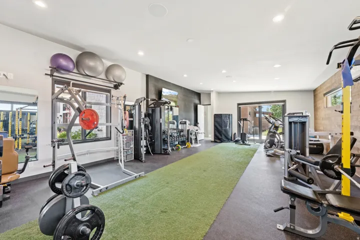 Dedicated fitness room featuring recessed lighting, a turf-style floor section, and black rubber flooring