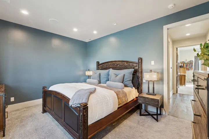 Bedroom with recessed lighting, blue painted walls, and light gray patterned carpeting
