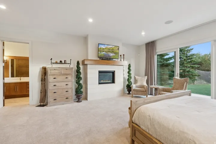 Carpeted room featuring a fireplace with a wood mantle, sliding glass doors, and recessed lighting
