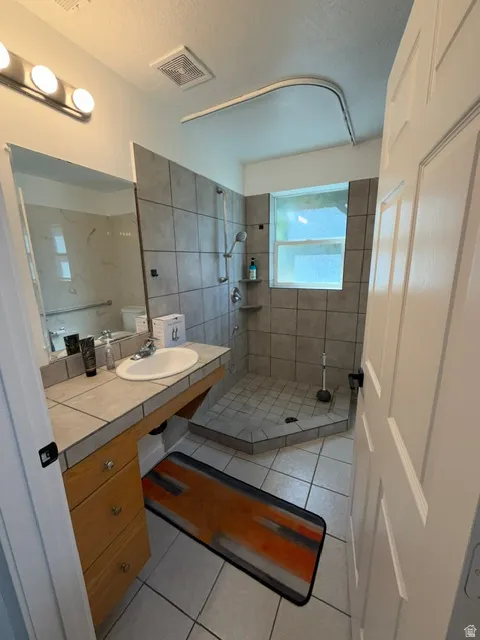 Bathroom featuring a tiled walk-in shower with a built-in corner shelf and an integrated window