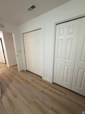 Light wood-finish flooring extending through the hallway
