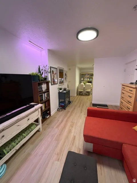 Open-concept living space featuring wood-finish flooring, recessed lighting, and a neutral color palette