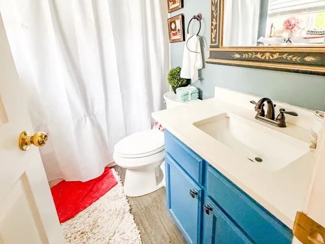 Bathroom featuring a white vanity with an integrated sink, blue cabinet storage, and a dark bronze faucet