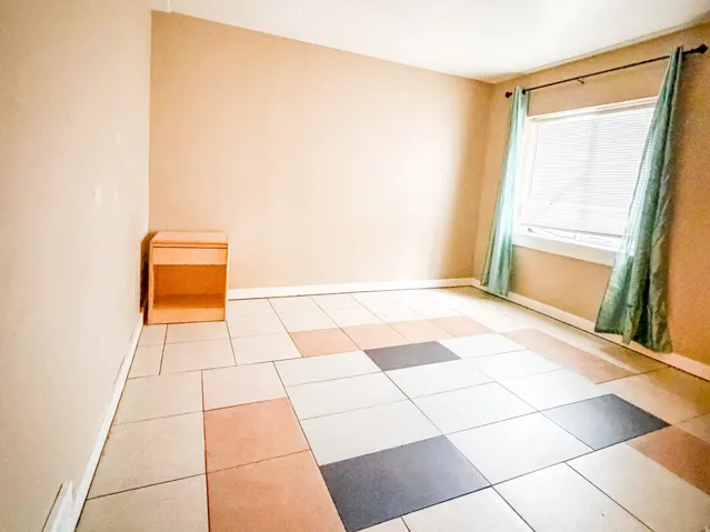 Room featuring patterned tile flooring with varied square and rectangular tiles