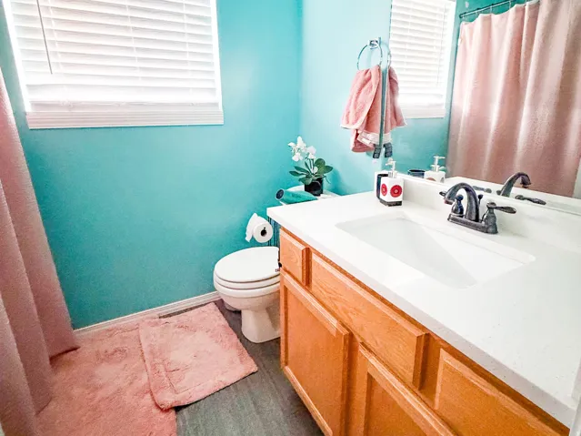 Bathroom featuring a single vanity with a white countertop and light wood cabinetry