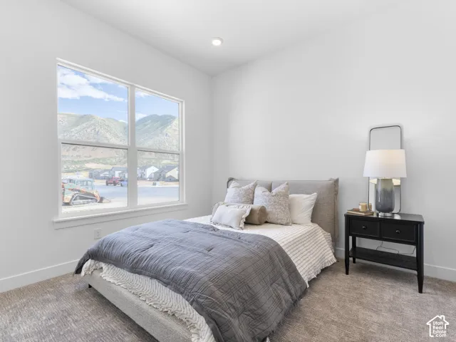 Recessed ceiling lighting, wall-to-wall carpeting, and a large window with white trim