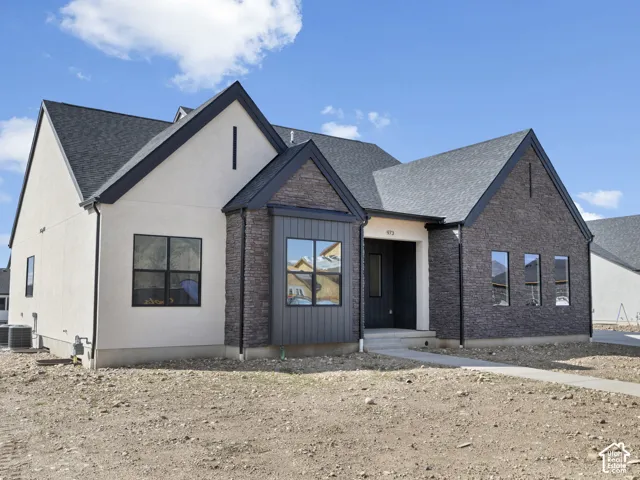 Contemporary exterior featuring stucco, dark brick, and vertical siding accents