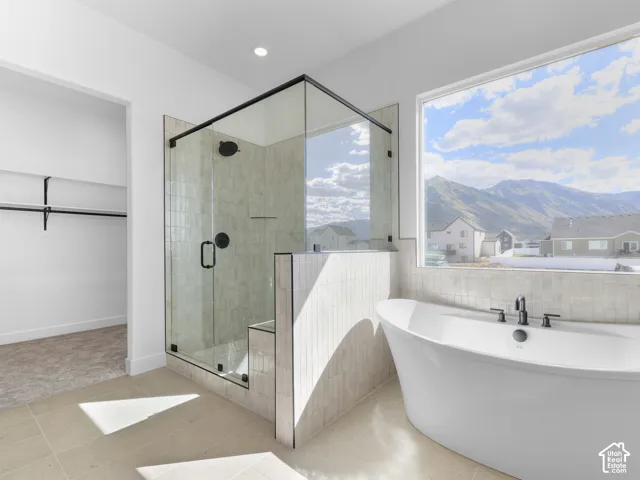 Freestanding soaking tub with matte black fixtures, set against a large picture window