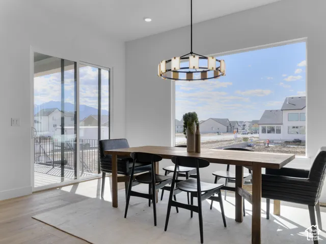 Recessed lighting, wood-finish flooring, sliding glass door, fixed picture window, and a contemporary ceiling fixture