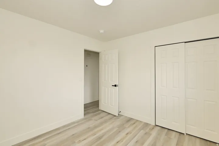 Room featuring light wood-finish flooring, crisp white walls, and a recessed ceiling light