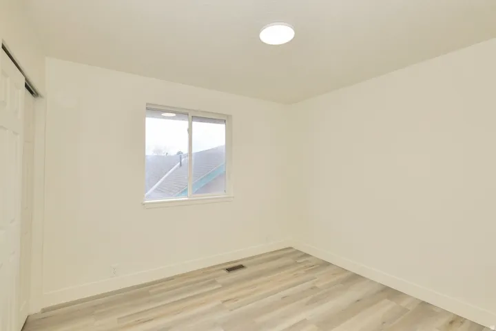 Room featuring light wood-finish flooring, white walls, and a recessed ceiling light fixture