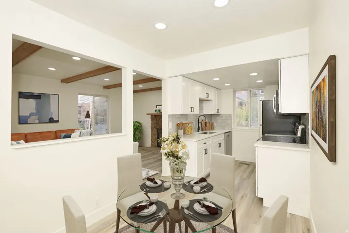 Bright dining area with a glass-top table, recessed lighting, and light-tone wood-finish flooring