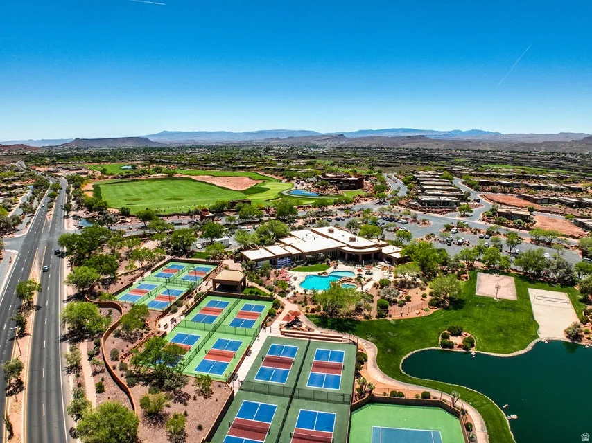 Expansive property featuring multiple sports courts, a large swimming pool, a golf course, and a tranquil pond