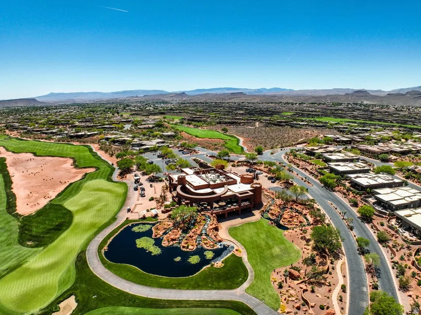 Expansive golf course with manicured greens, surrounding desert landscaping, and a large central building with multiple terraces