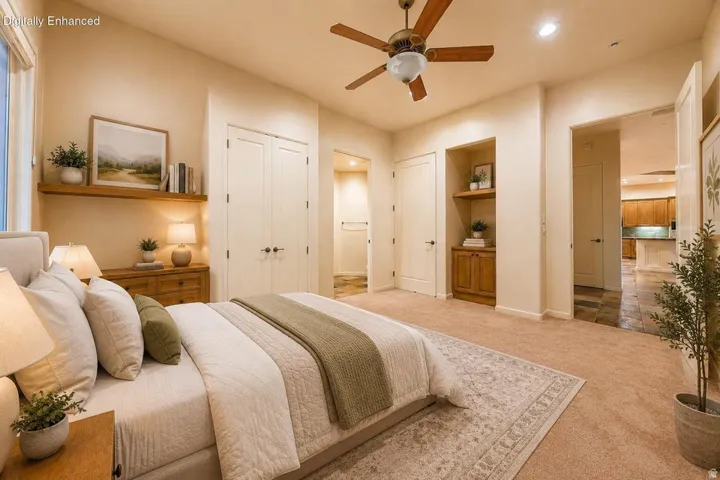 Plush carpet flooring, wood-finish ceiling fan, built-in shelving with wood-finish cabinetry, and double-door closets