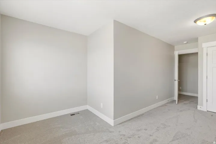 Carpeted room with light gray walls, white baseboards, and a white ceiling