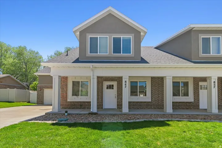 Modern townhome exterior featuring a combination of brick and stucco finishes. Nice architectural pillars in front