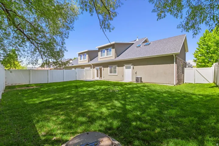 Expansive grassy yard with full vinyl fencing