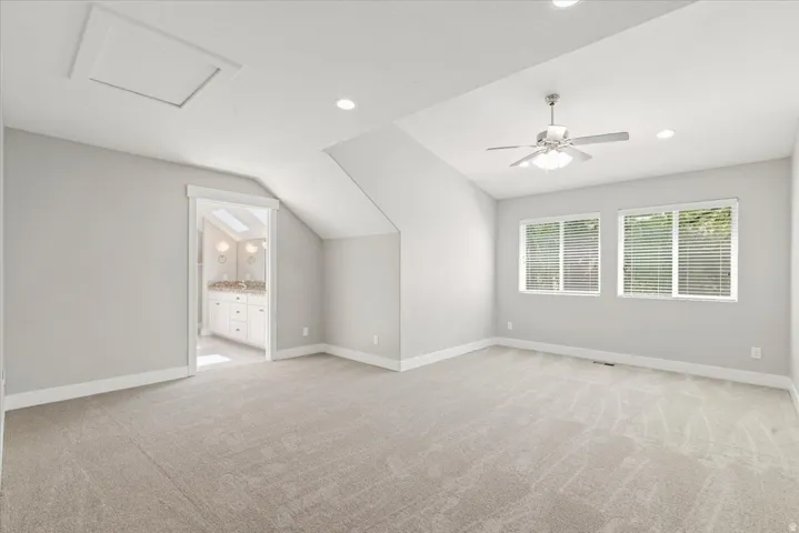 Master bedroom. Carpeted room featuring a vaulted ceiling with a ceiling fan, recessed lighting, and three windows with blinds