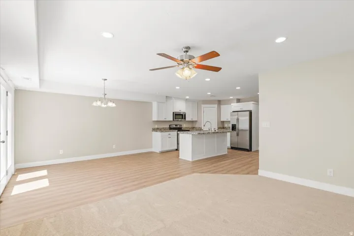Open-concept living space with recessed lighting and a ceiling fan