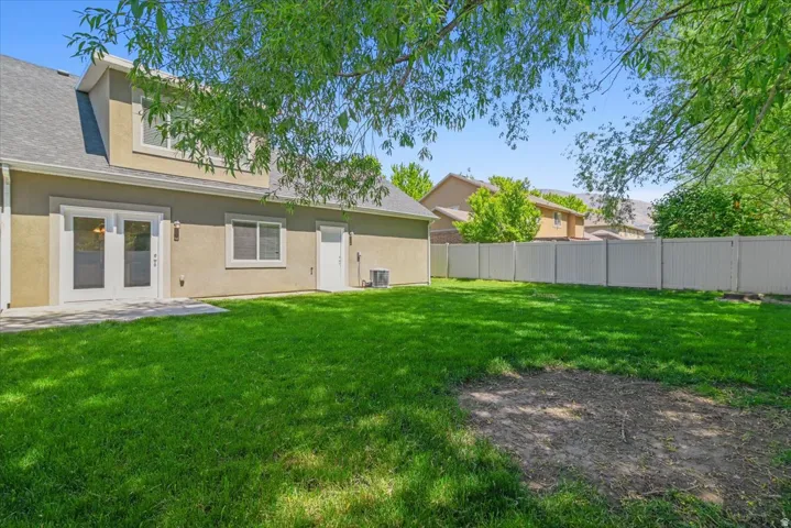 Expansive green lawn with a white privacy fence