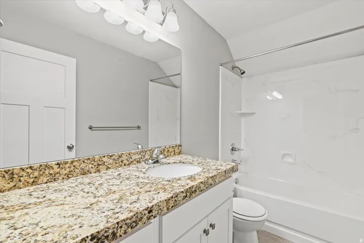 Full Bathroom featuring a vanity with a granite countertop, undermount sink, and chrome fixtures