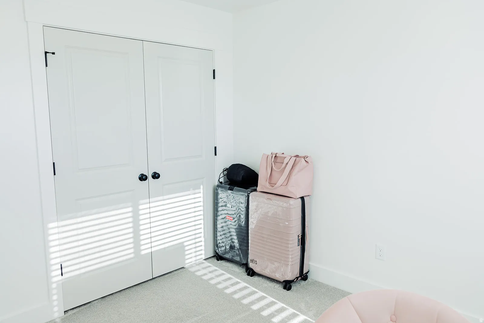 White double-panel closet doors with black hardware