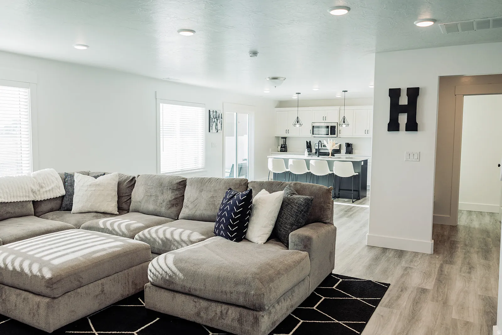 Open-concept living space featuring wood-finish flooring, recessed lighting, and white walls