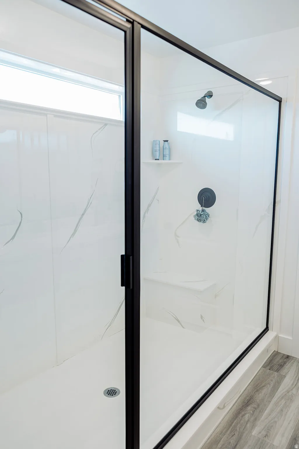 Frameless glass shower enclosure with matte black trim and hardware