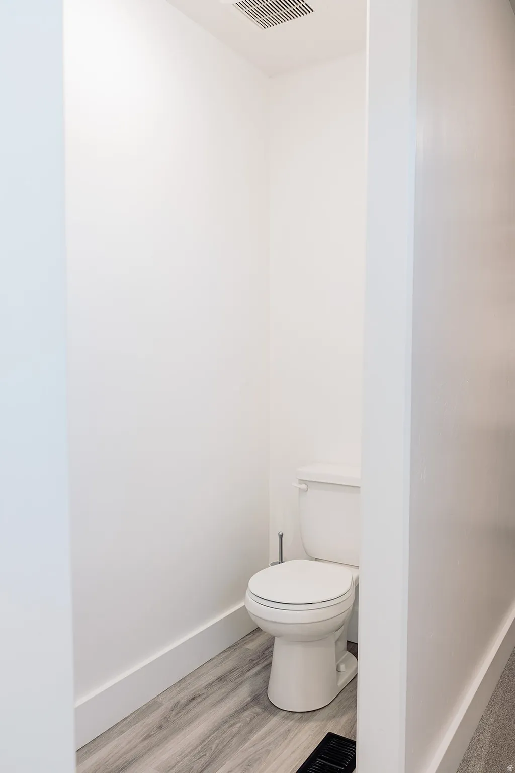 Master Bathroom featuring a single toilet, wood-finish flooring, white baseboards, a ceiling vent, and recessed lighting